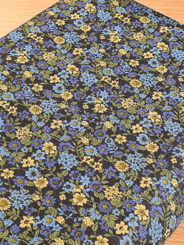 "Petites fleurs bleues" sur fond noir de marque Kokka (prix pour 10cm)